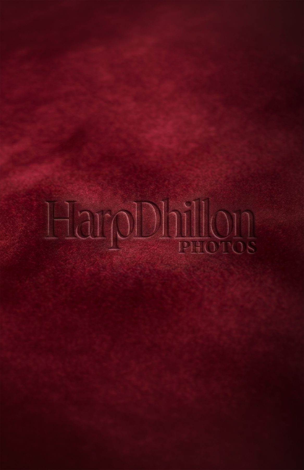 HarpDhillon Photos logo embossed in deep red velvet